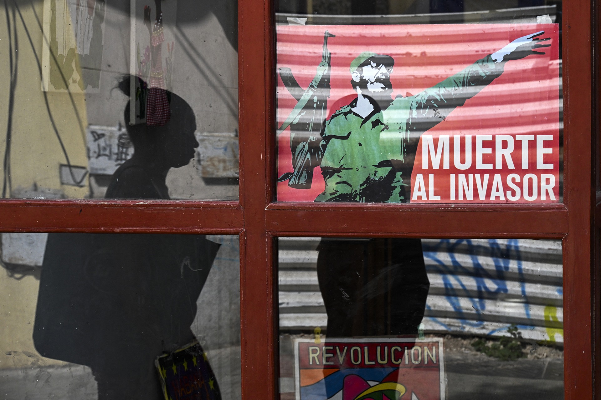 <p>A woman walks past a poster of late Cuban leader Fidel Castro reading, “Death to the invader” in Havana, on March 13, 2026.</p>
