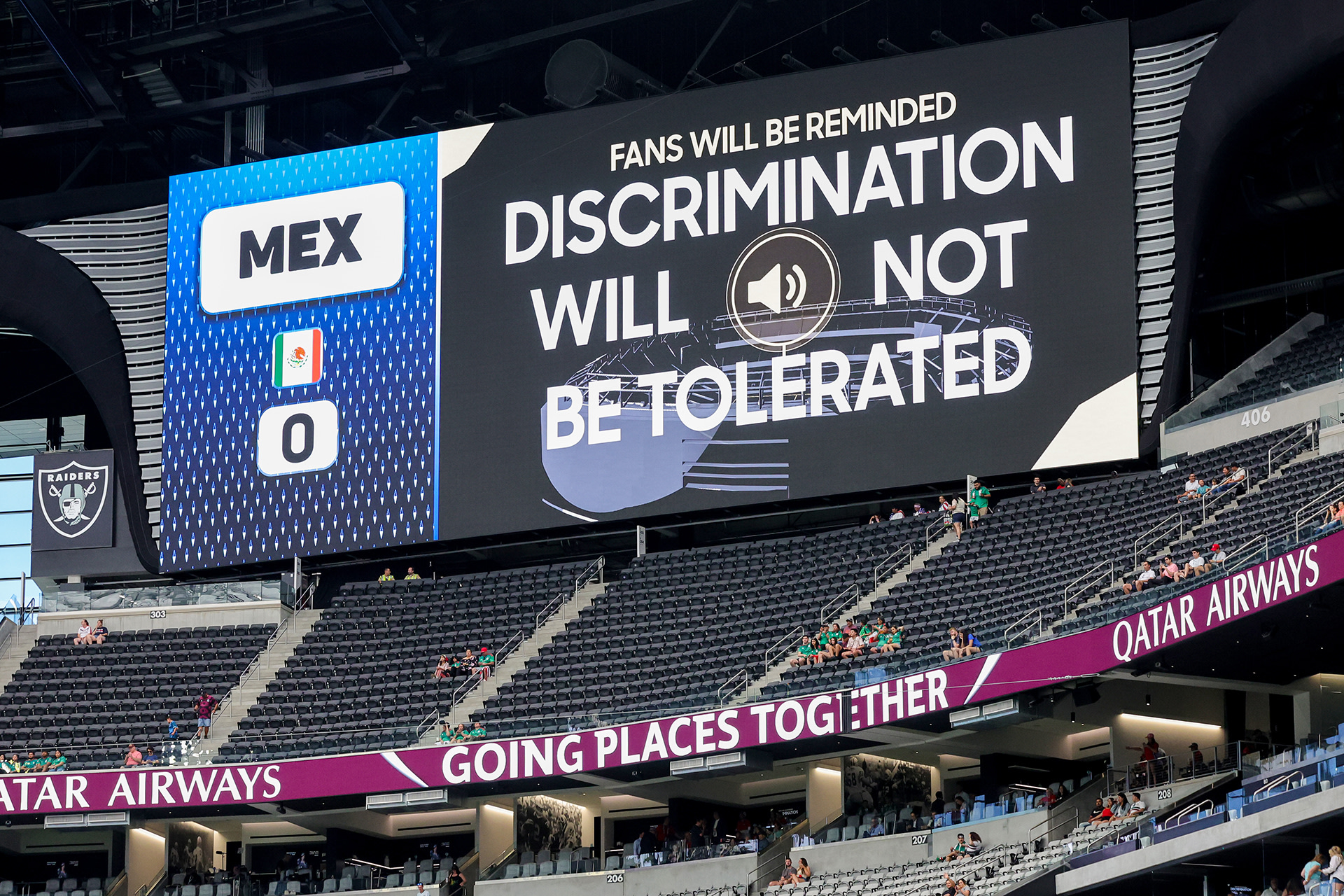 A jumbotron board above the seating in a stadium displays the message: "Fans will be reminded discrimination will not be tolerated".