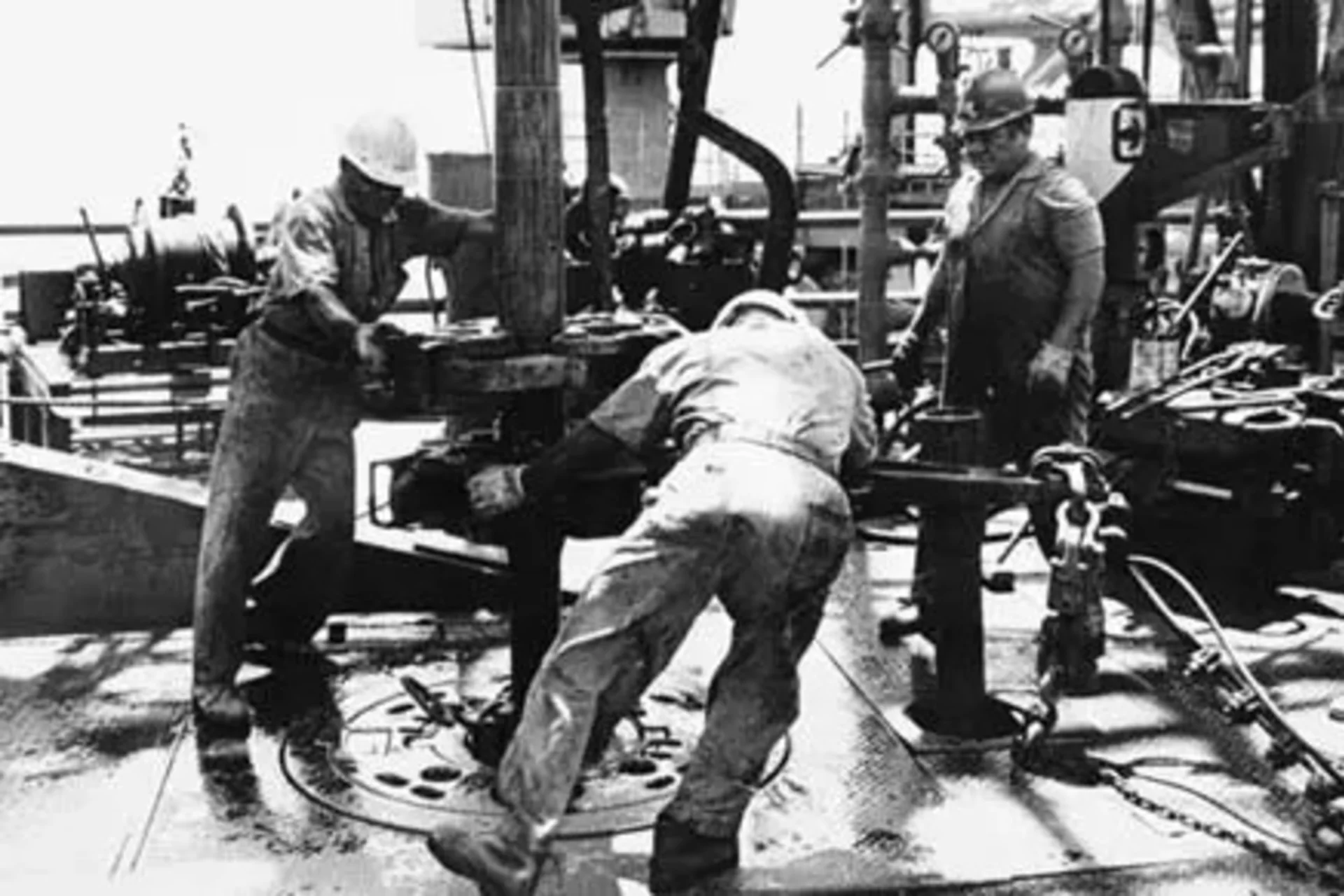 Workers aboard the Odessa, an offshore oil rig, prepare a new drilling bit. AP Images
