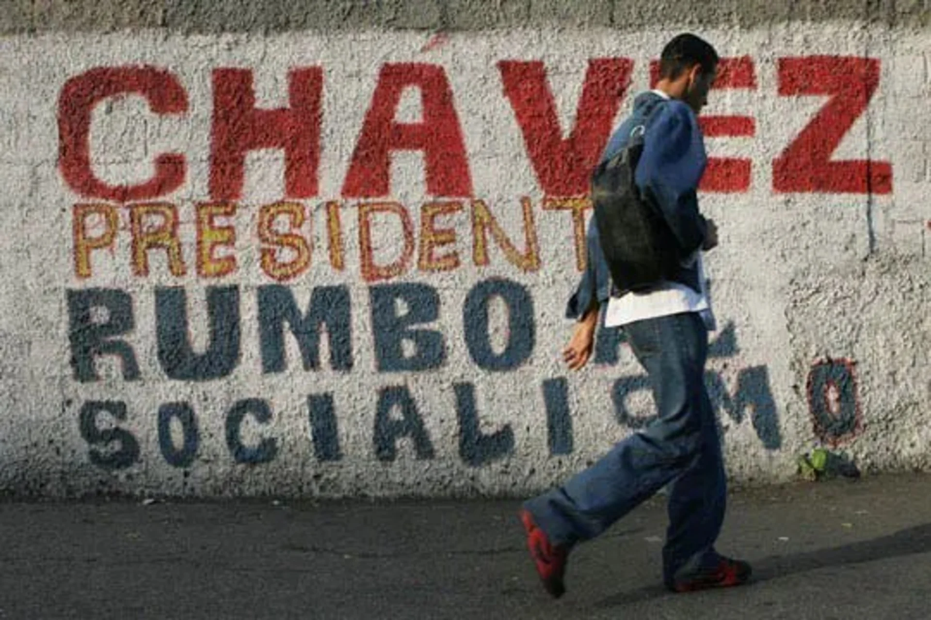 The mural reads "Chávez, President, on the way to socialism." 
