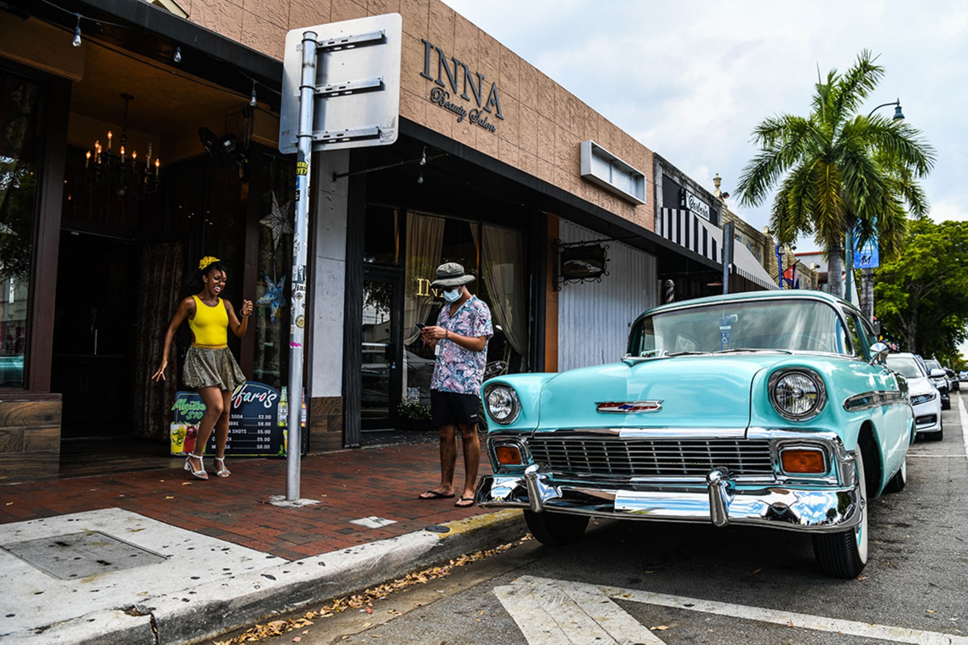 Two people stand outside a restaurant in a Cuban neighborhood of Miami, Florida. 
