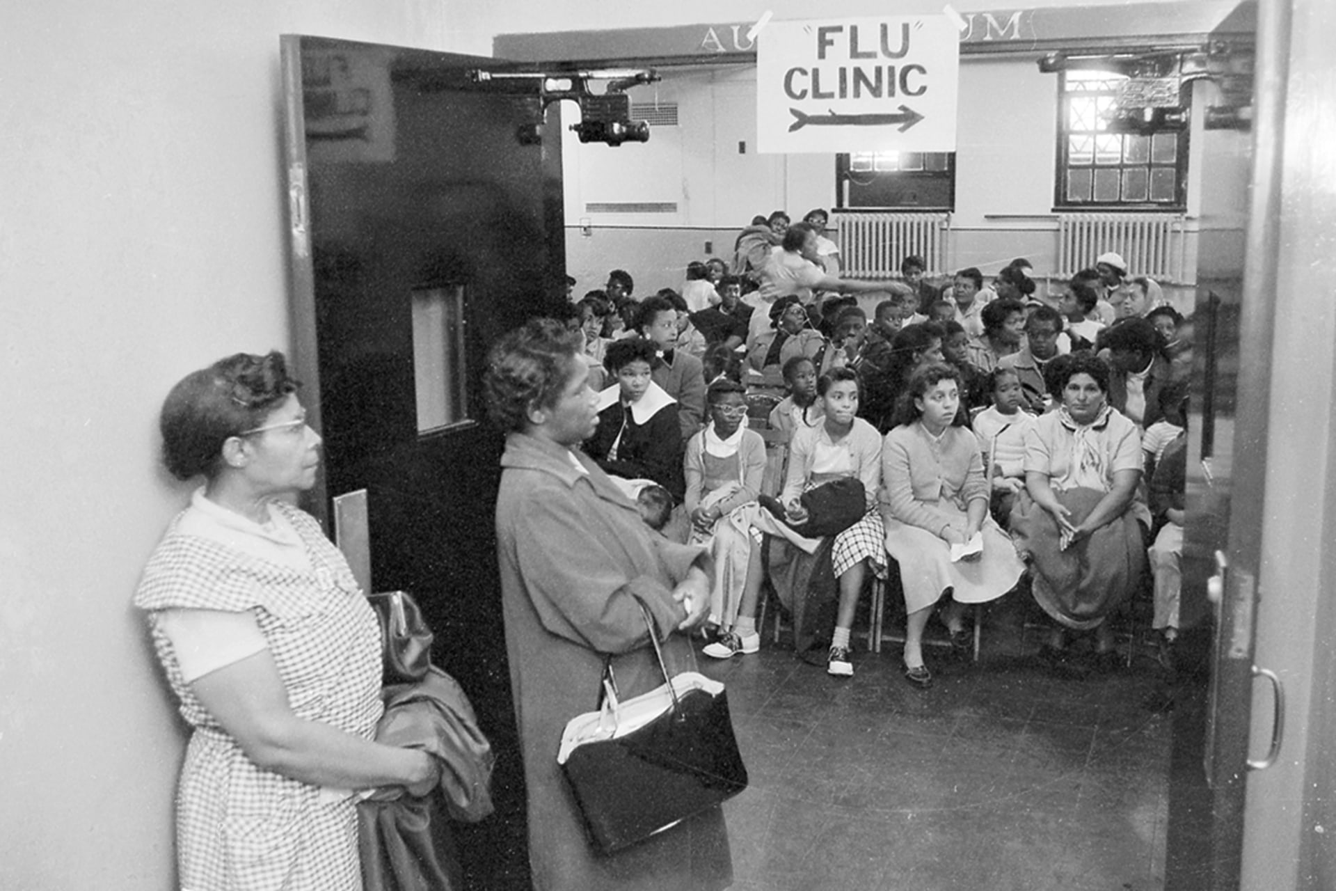 People wait at a health clinic in New York City’s Harlem neighborhood in October 1957. Bettmann/Getty Images