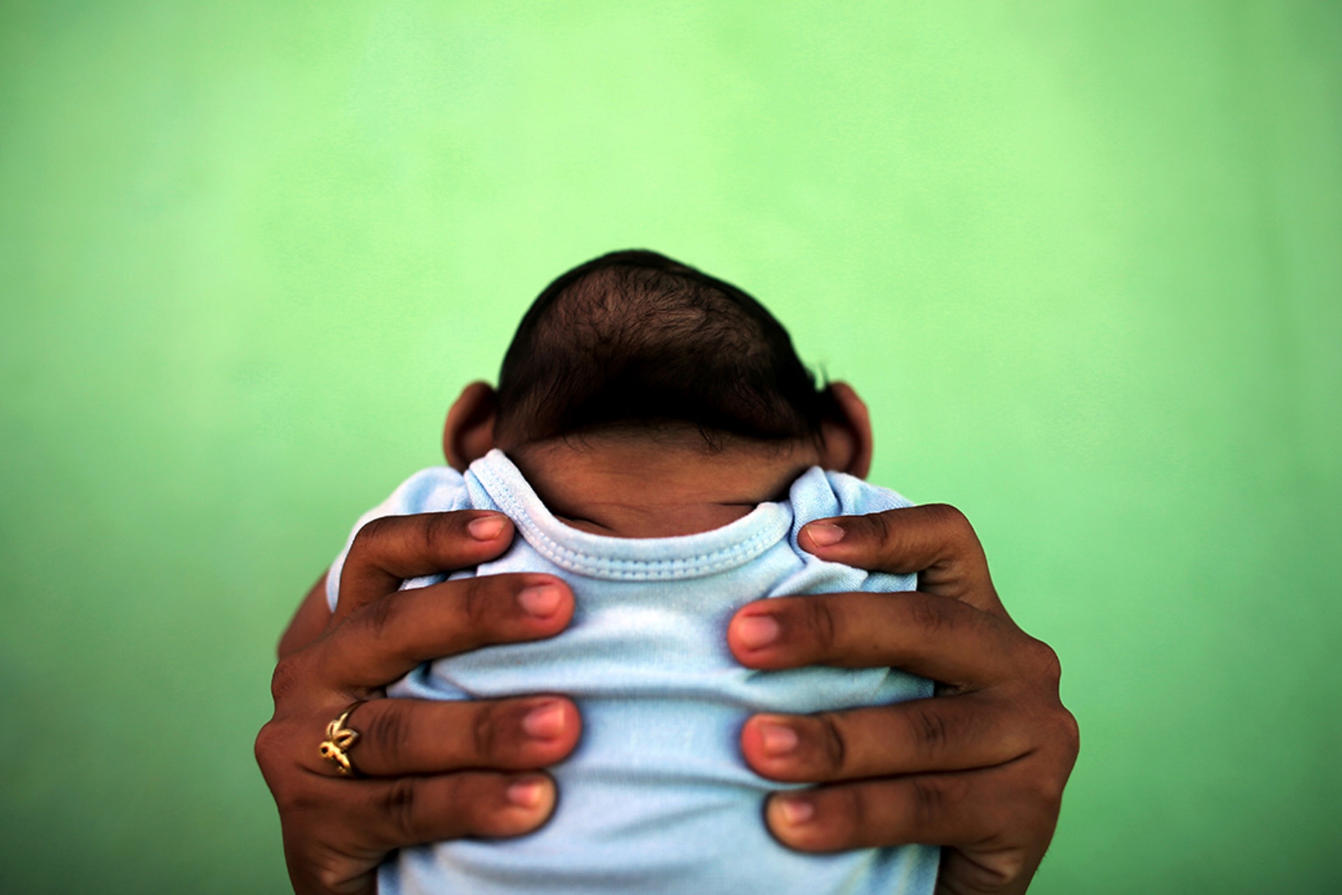 A baby born with microcephaly is held by his mother in front of their home in Olinda, Brazil, in February 2016. Nacho Doce/Reuters