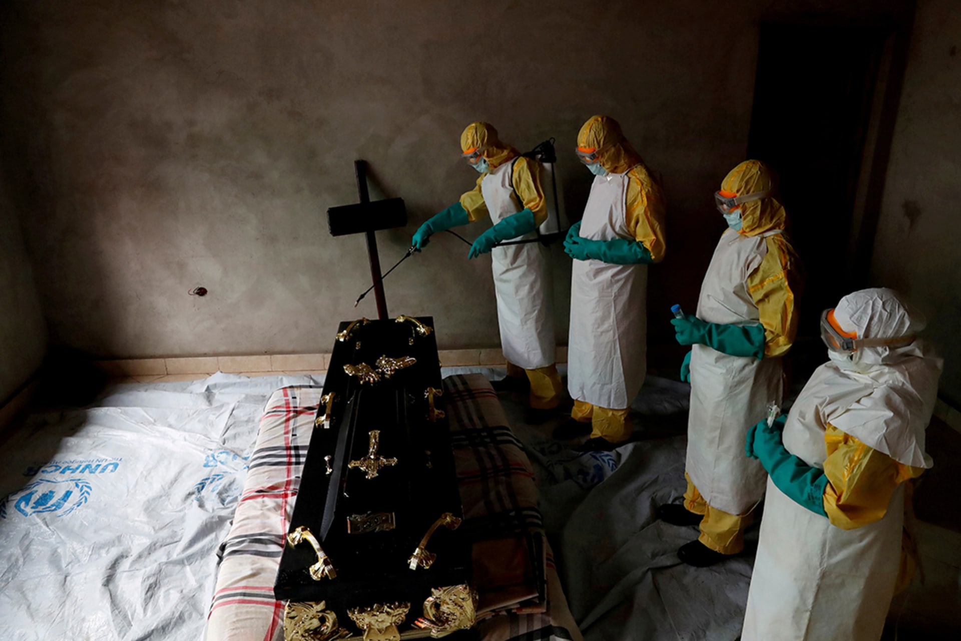 A health-care worker sprays a room during the funeral of a suspected Ebola victim in Beni, Democratic Republic of Congo, in December 2018. Goran Tomasevic/Reuters