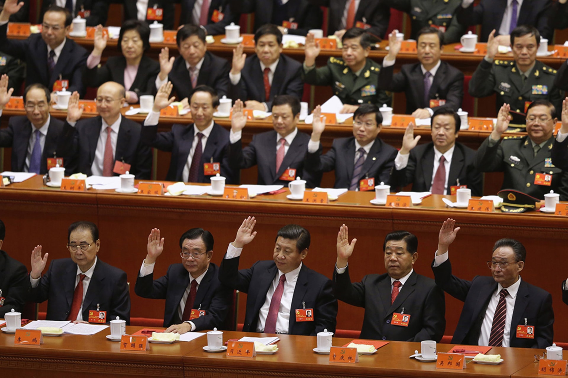 Xi Jinping (front, third from left) and other delegates vote during the 18th National Party Congress in Beijing. 
