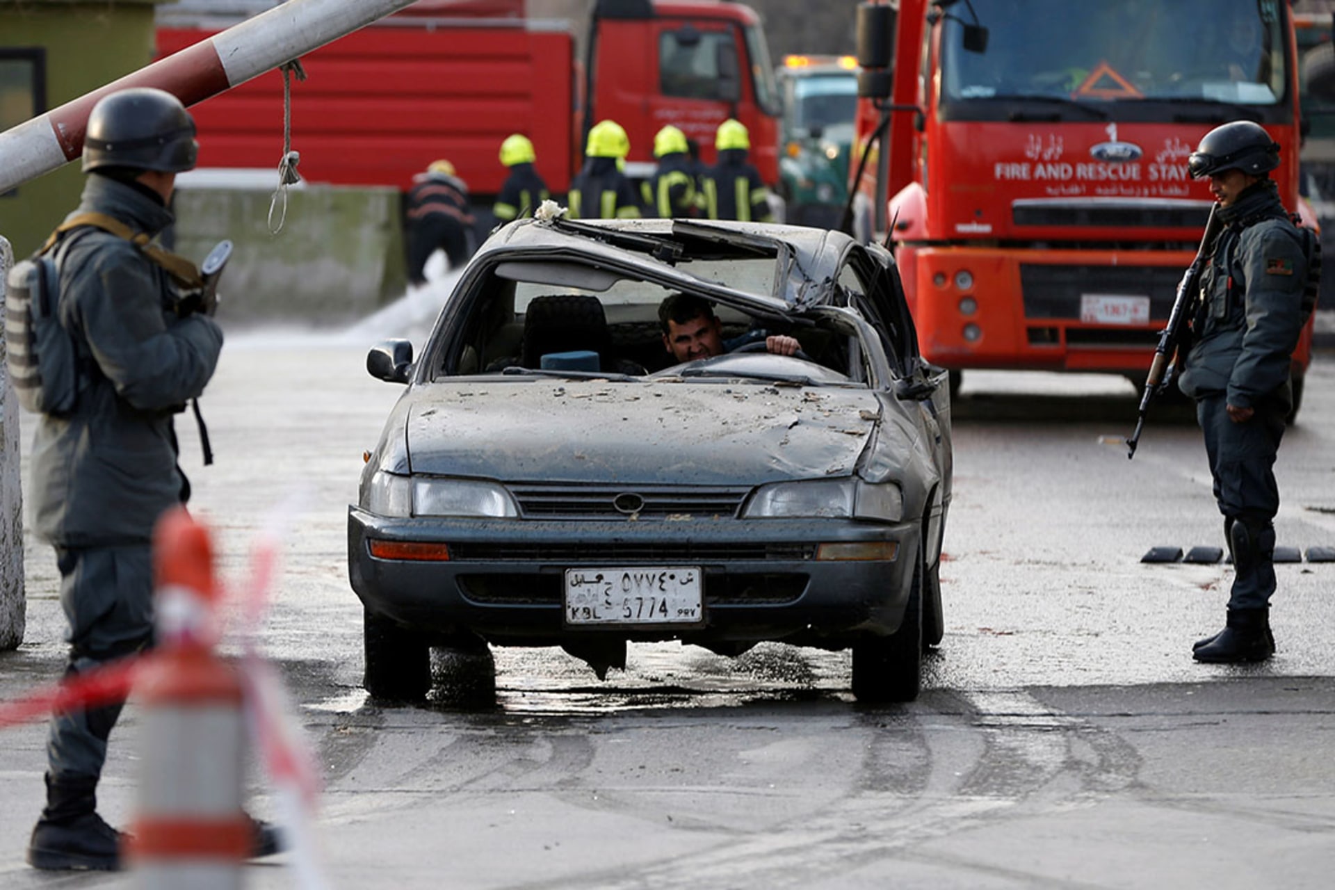 Police officers keep watch at the site of a car bomb attack in Kabul.