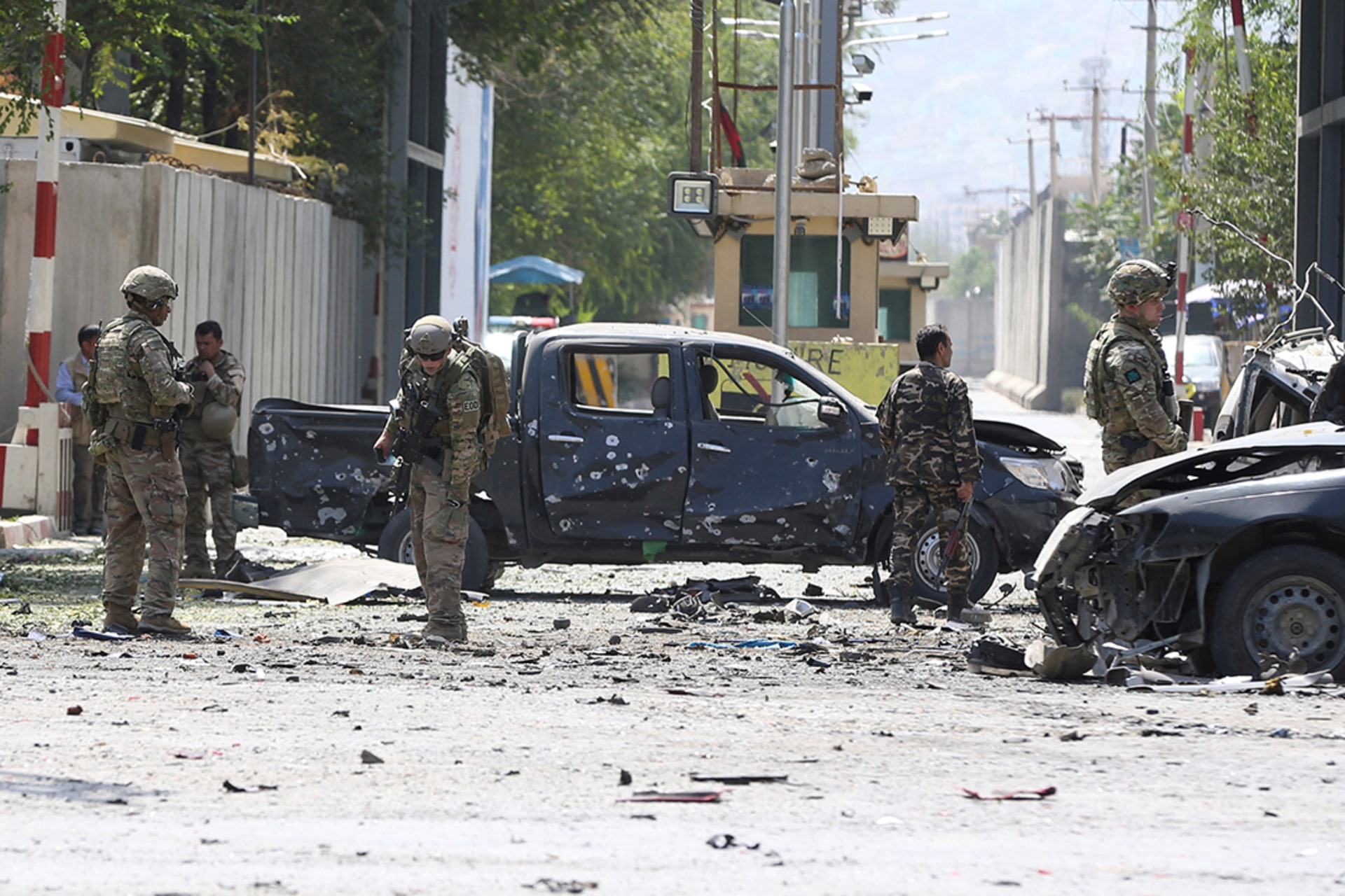 Troops investigate the site of a car bomb attack that the Taliban says it carried out. 