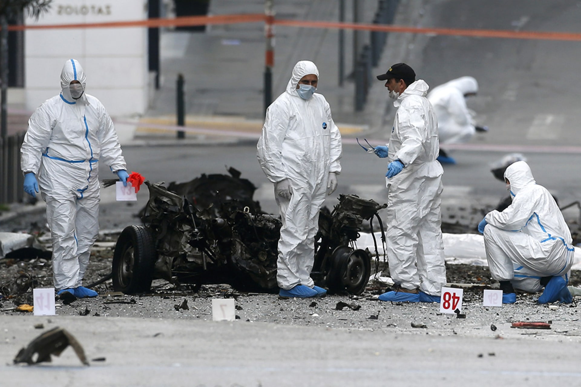Forensic experts search for evidence at the site of a car bombing in Athens on April 10, 2014.