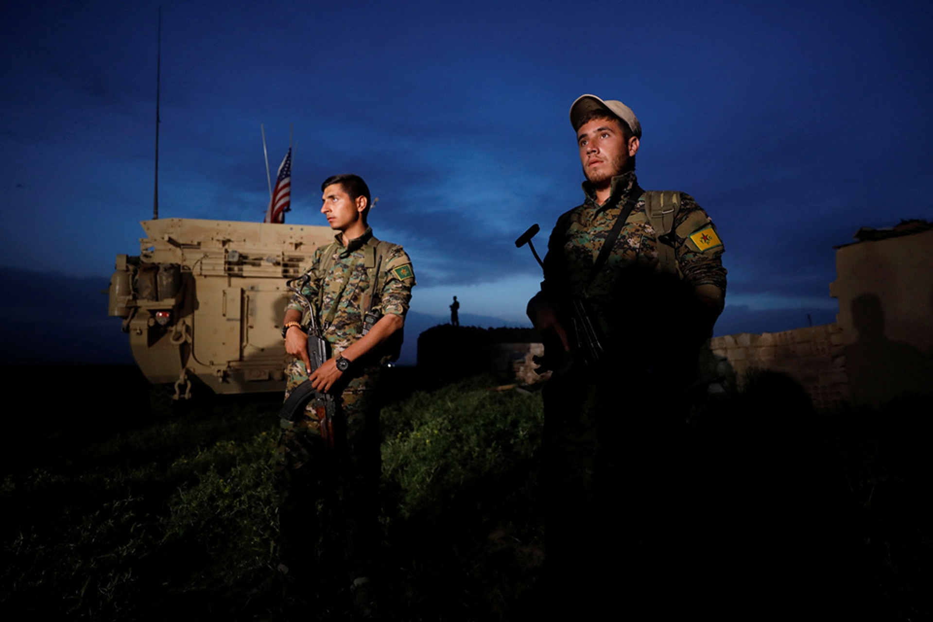 YPG fighters stand by a U.S. military vehicle near Syria’s border with Turkey. 
