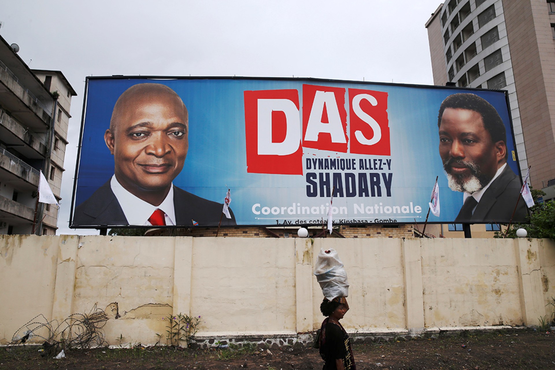 A woman walks past a billboard advertising Kabila’s support for candidate Emmanuel Ramazani Shadary. Baz Ratner/Reuters