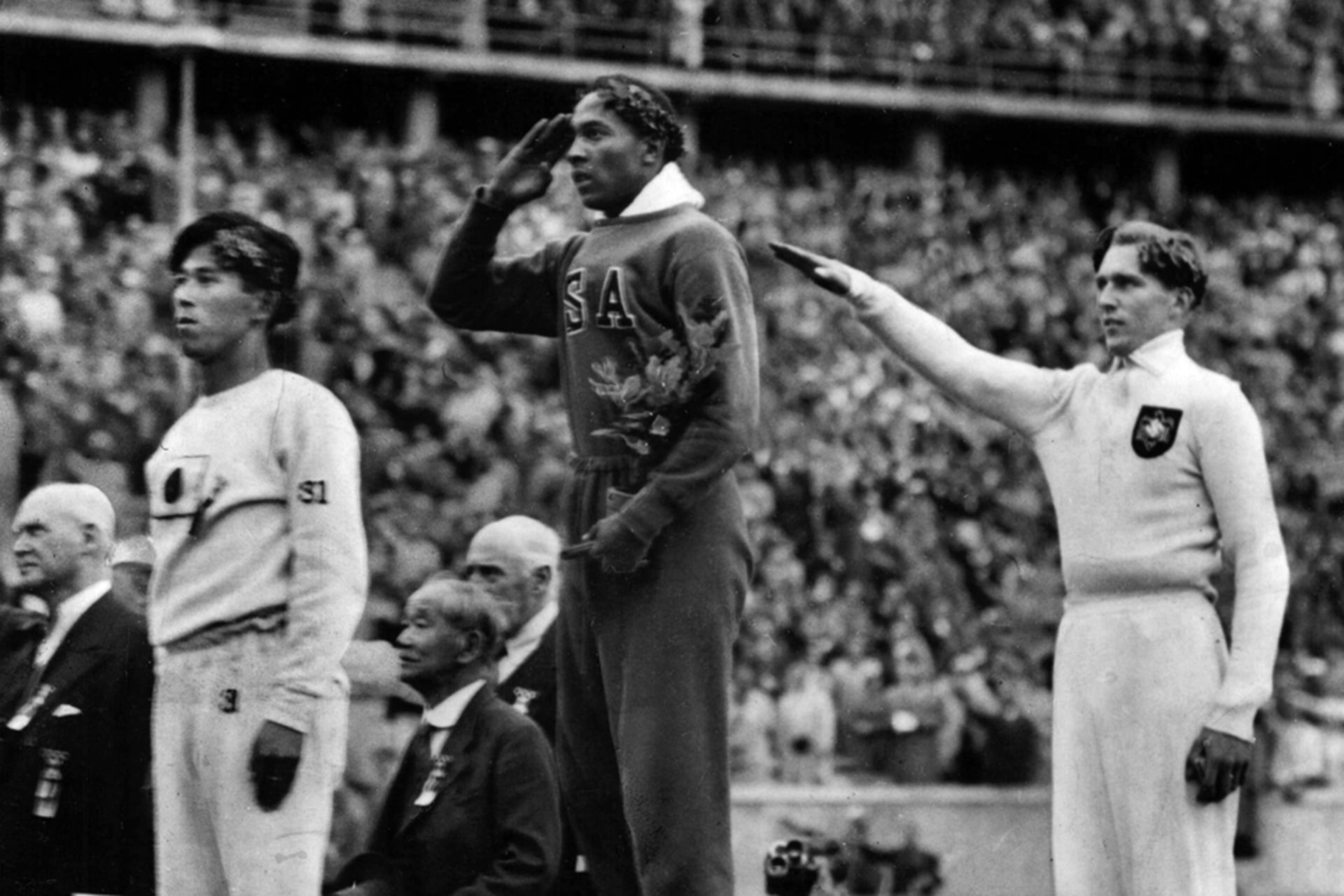 U.S. athlete Jesse Owens (center) salutes after defeating Nazi Germany’s Lutz Long (right) in the long jump in Berlin. Japan’s Naoto Tajima (left) places third. AP Photo