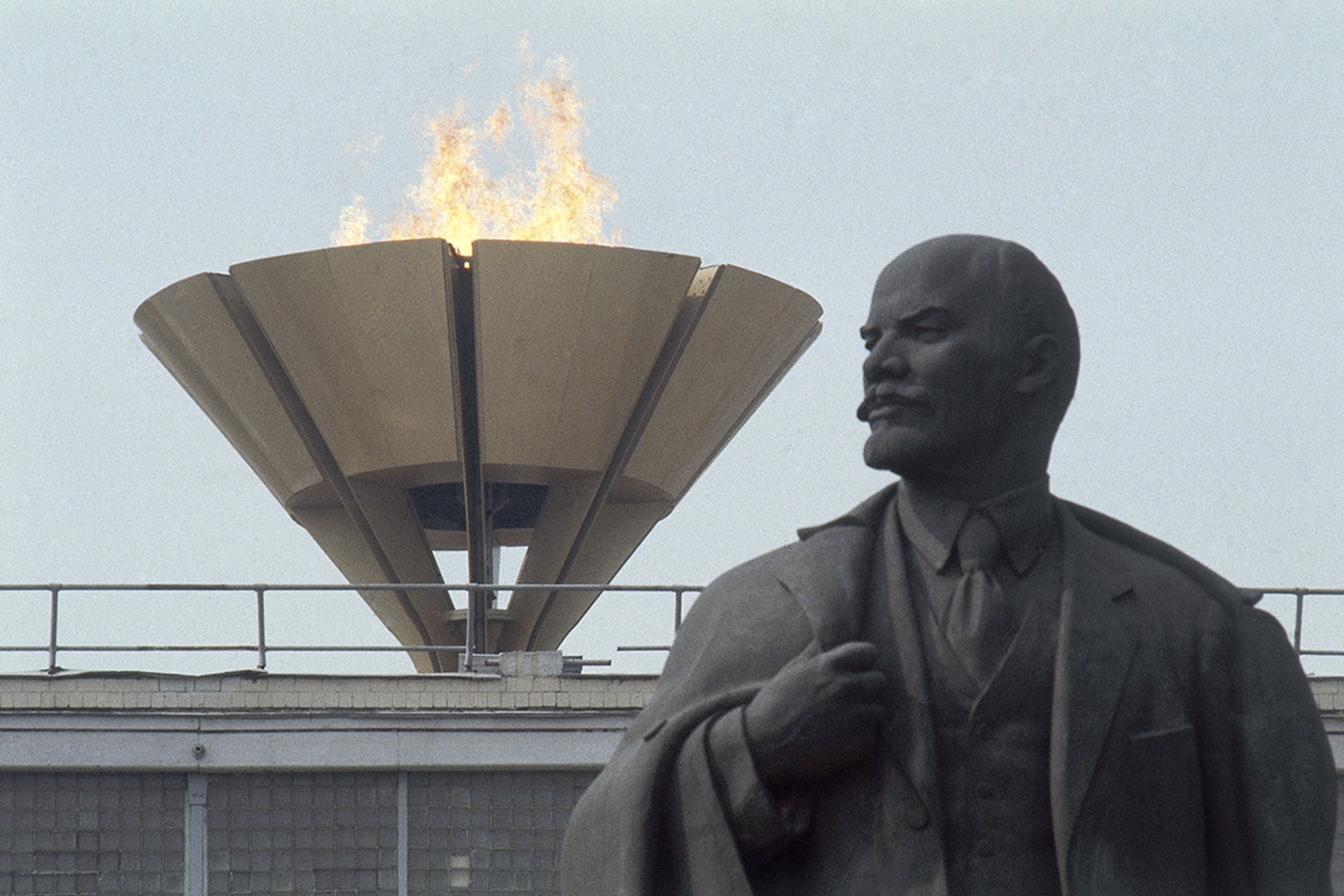 The Olympic flame burns above a statue of former Soviet leader Vladimir Lenin in Moscow. AP Photo
