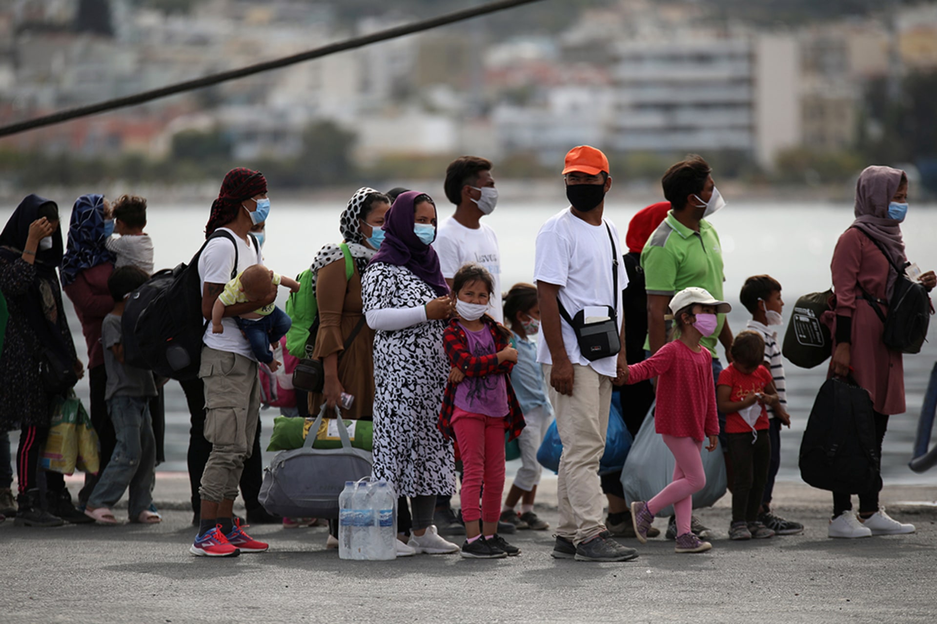 People from the fire-ravaged Moria refugee camp wait to board a ferry on the island of Lesbos, Greece, in September 2020. Elias Marcou/Reuters