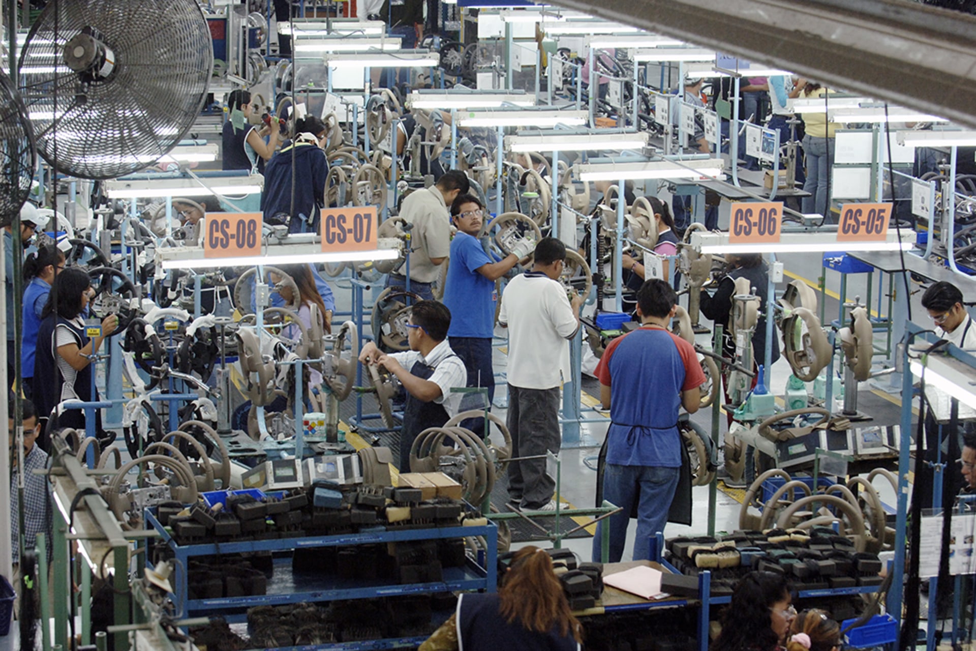 Mexican workers produce steering wheels at Delphi Delco Electronics, a maquiladora plant that builds parts for General Motors. Robert Daemmrich Photography Inc/Corbis/Getty Images