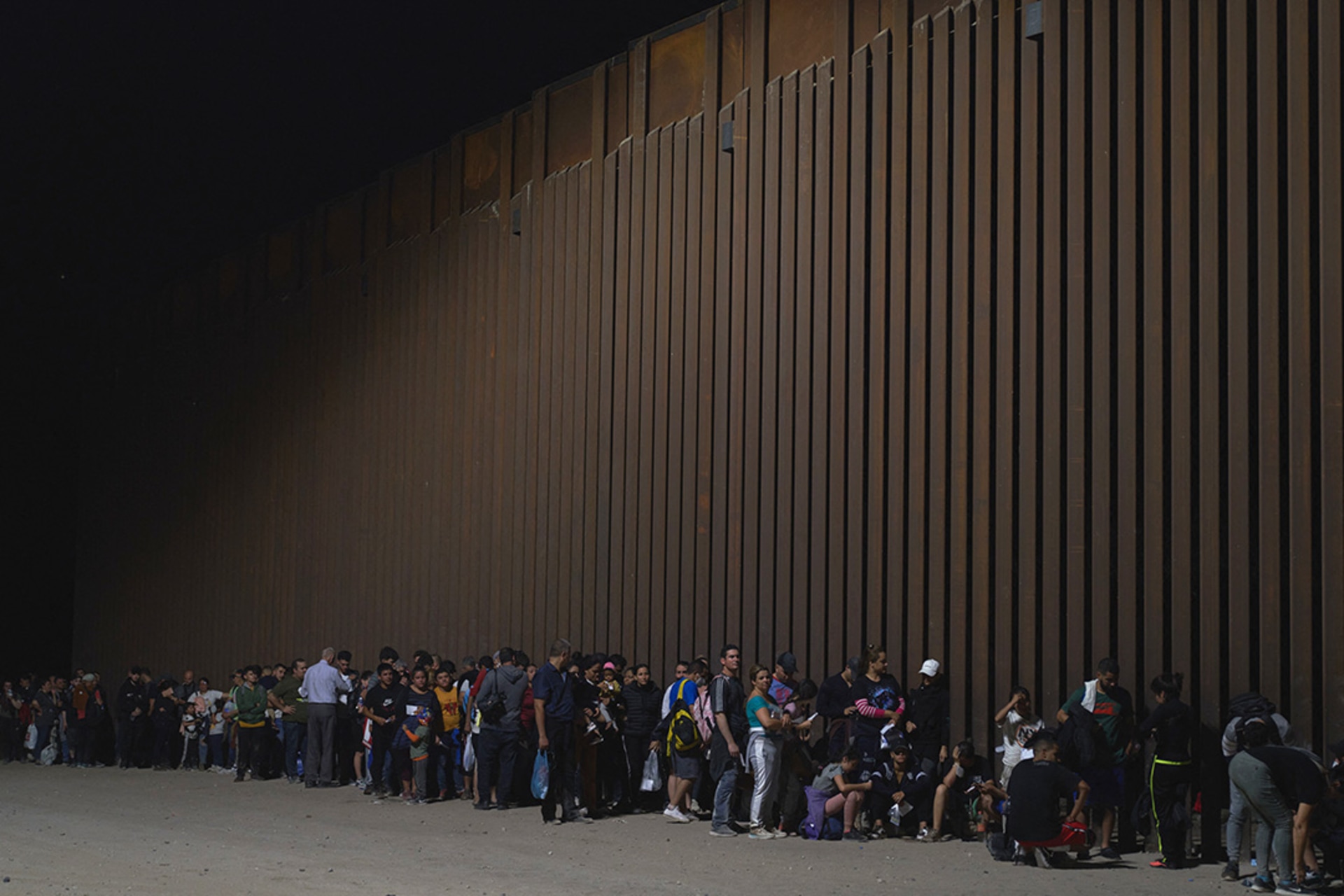 Dozens of migrants wait to be processed by U.S. Border Patrol in Yuma, Arizona. Allison Dinner/AFP/Getty Images