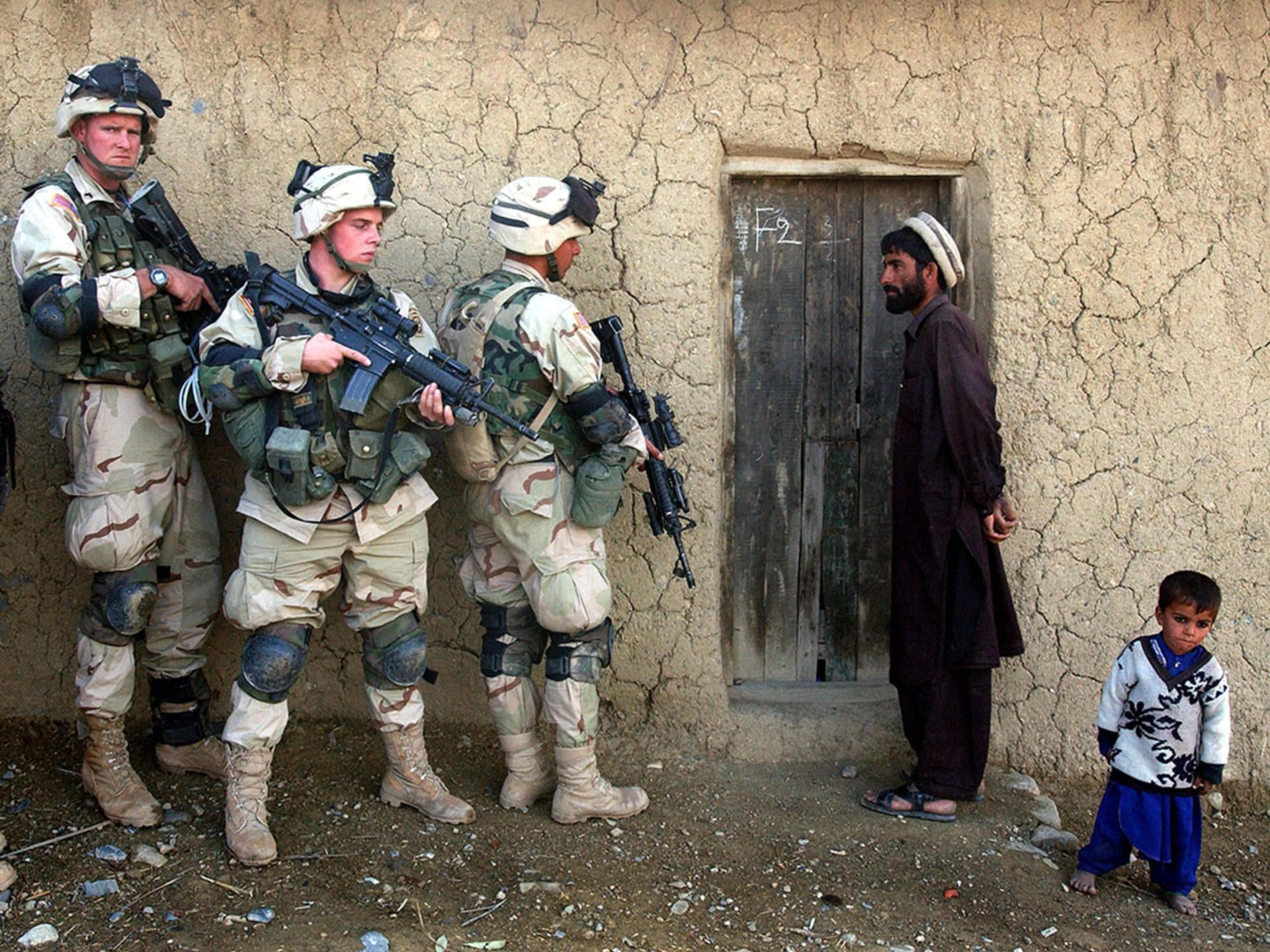 U.S. soldiers prepare to sweep the home of an Afghan man in November 2002. Scott Nelson/Getty Images
