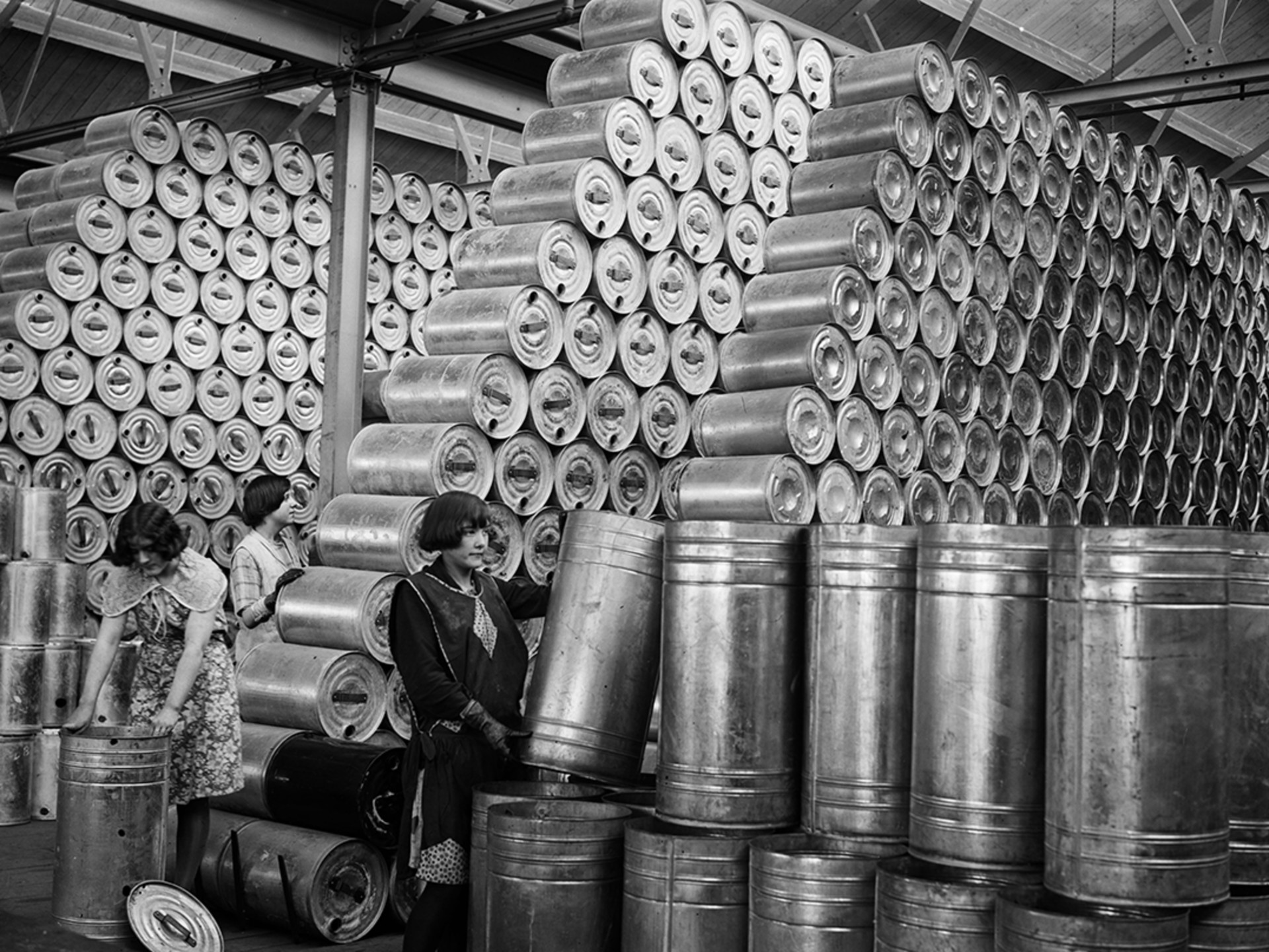 Workers at a factory stacking drums of oil in a warehouse, February 1930.