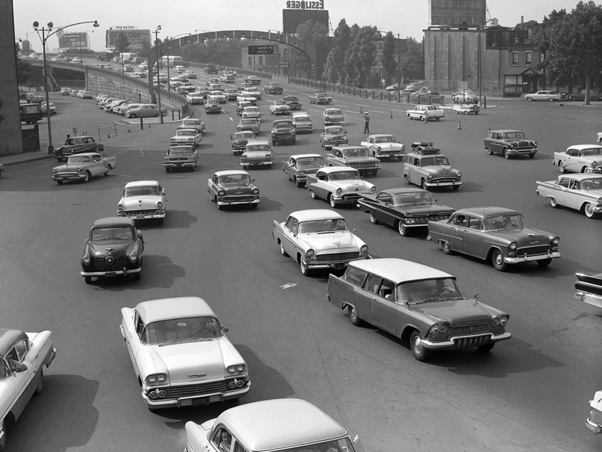 Cars crowd the exit ramp off a highway in the 1950s. H. 
