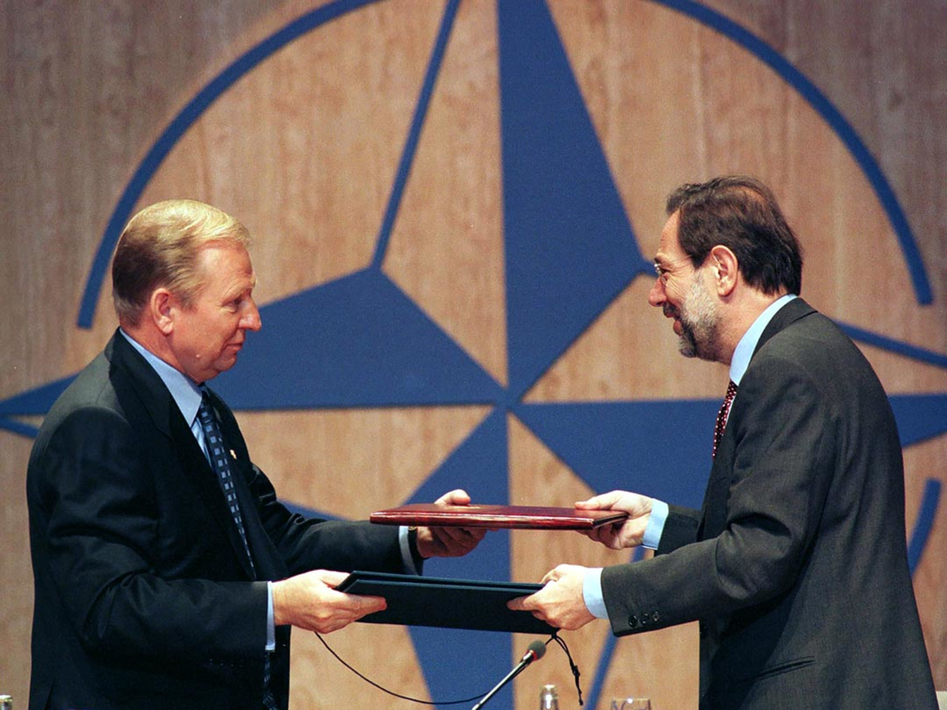 Ukrainian President Leonid Kuchma exchanges documents with NATO Secretary-General Javier Solana after a signing ceremony during the NATO summit.
